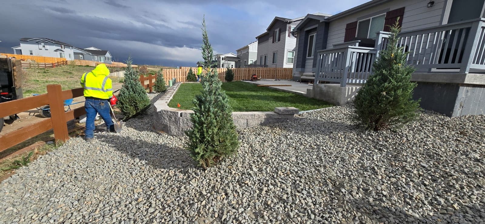 Landscaping project with sod, retaining wall, and crew on site